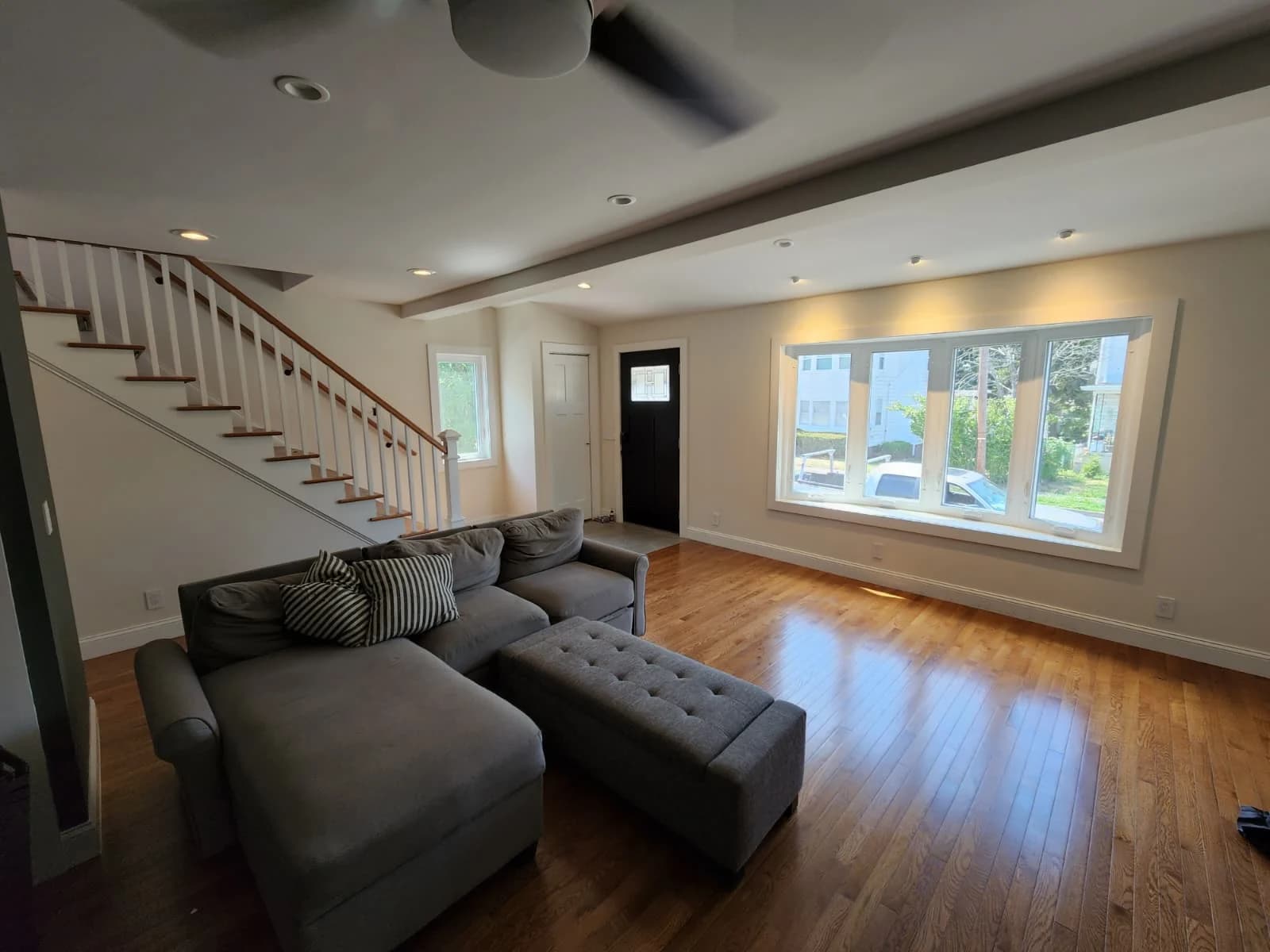 Living room with wood floors and a white-baluster staircase from the Innova project archive