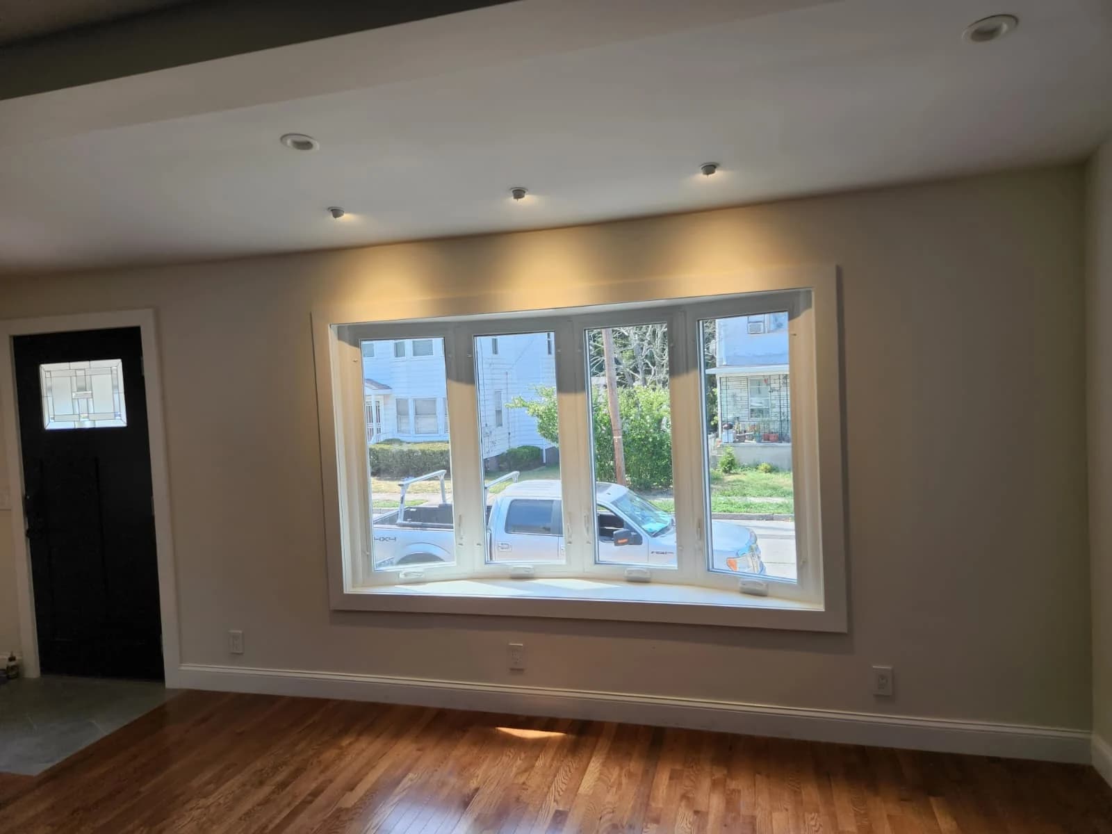 Wood flooring and broad picture window in an Innova living room renovation